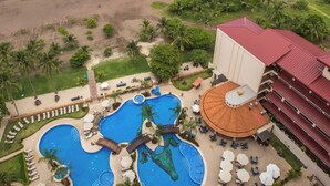 A resort with multiple swimming pools, a beach, and a view of the ocean.