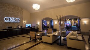 A Croc's Casino Resort lobby with a reception desk, seating area, and arcade games.