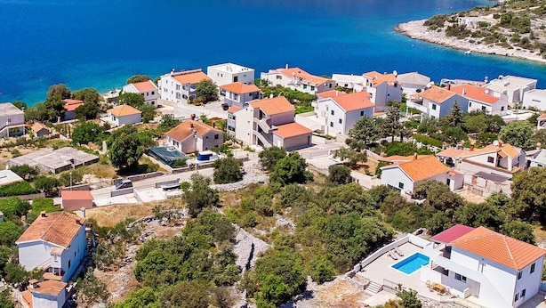 A coastal village with white buildings and red roofs, a clear blue sea, and a small pool area. - Villa Dupla Kanica (Kanica)