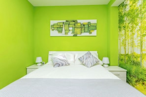 A bedroom with a bed, two bedside tables, and a wall art piece. - Apartment Marija (Omis)