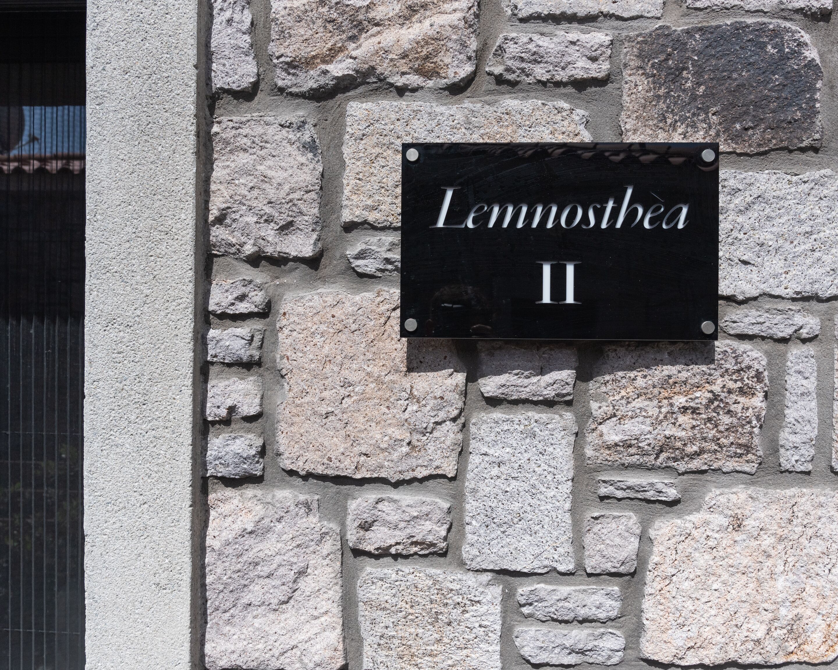 A stone wall with a black sign that reads "Lennosthea II".