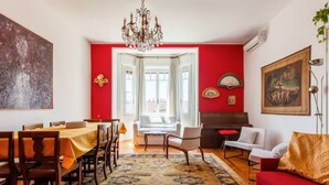 A dining area with a table set for six, a sofa, and a chandelier. - Dream House (Milano)