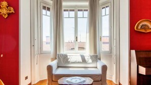 A room with a white sofa, a small table, and a window with curtains. - Dream House (Milano)