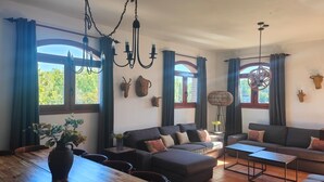 Ein geräumiges Wohnzimmer mit einem Holzesstisch, zwei Sofas und einer Kristallleuchter.