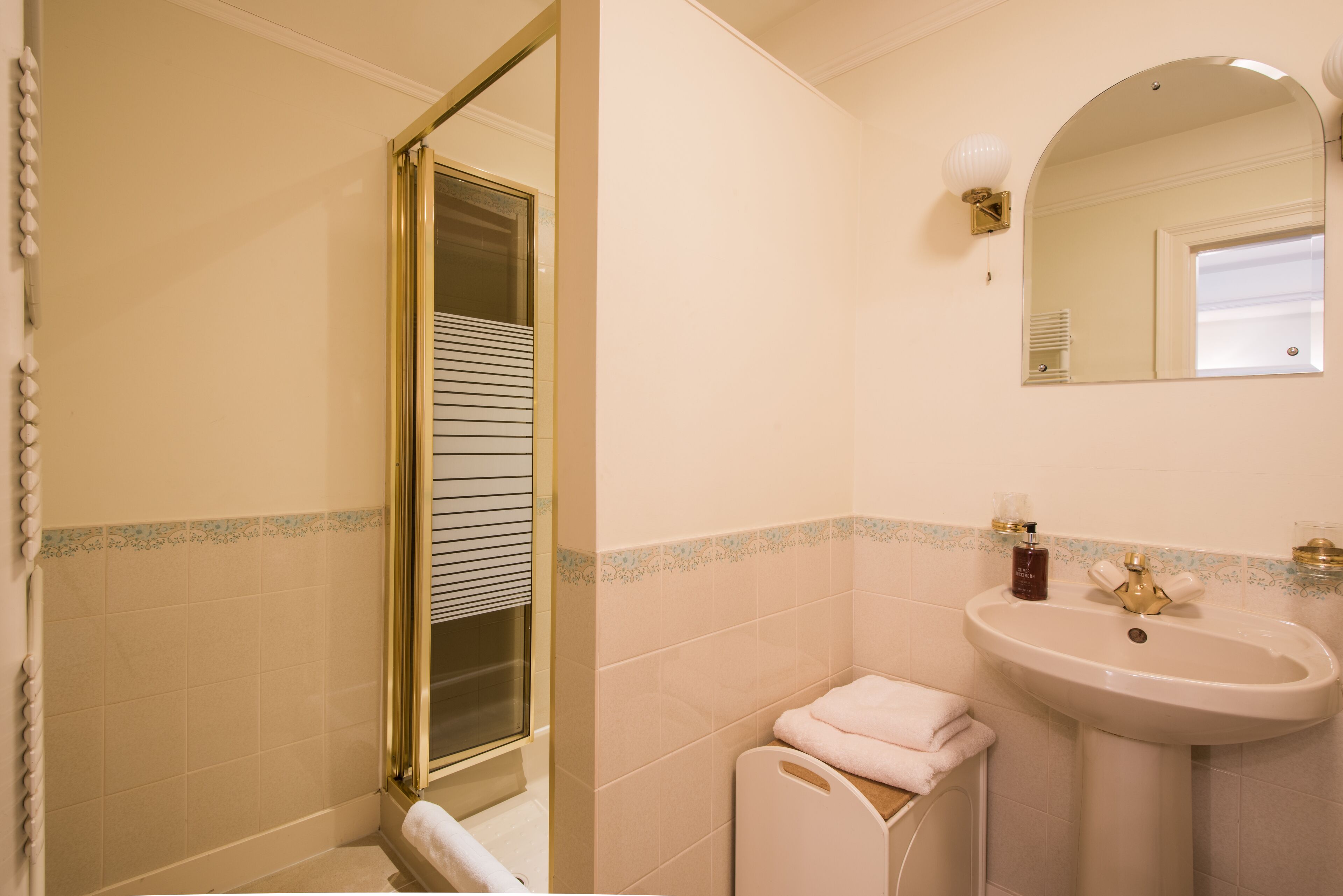 Un baño con ducha, lavabo y espejo.
