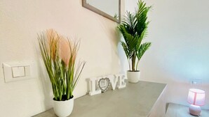 A bathroom with a white countertop, two potted plants, and a 'LOVE' sign. - Appartamenti San Teodoro IV con BBQ, A/C e WIFI (San Teodoro)