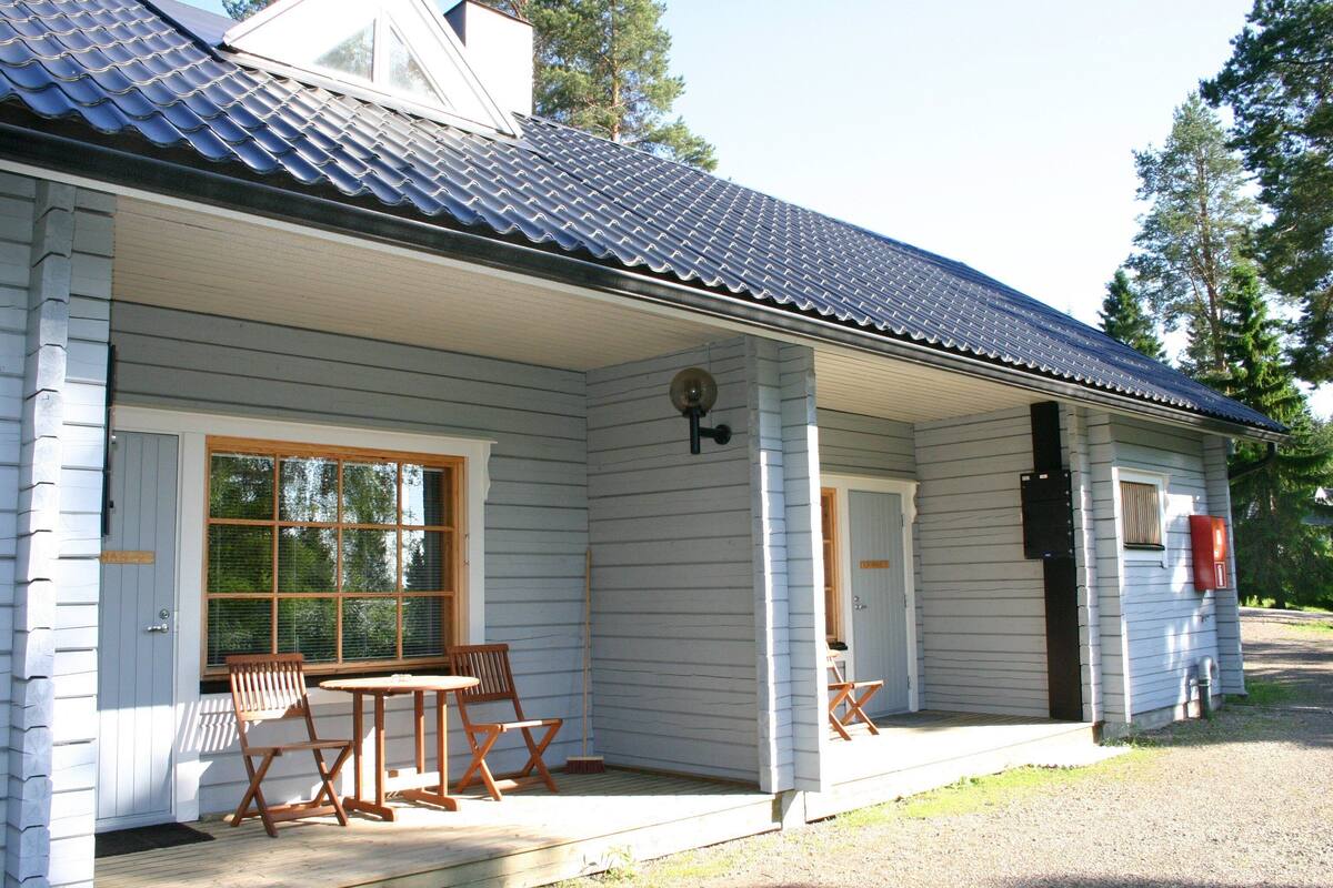 Ein Haus mit einer Veranda, einem Tisch und vier Stühlen.