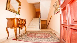 A staircase with a wooden railing, a wooden cabinet with a mirror, and a patterned rug on the floor. - Apartments "Labinac" Pula- Apartment I (Pula)