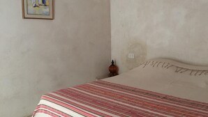 A bedroom with a bed, a framed painting, and a small decorative item on the wall. - Independent Villa With Private Pool, Covered Parking (Mezraia)