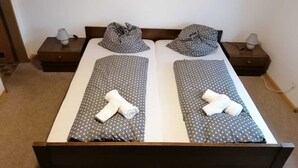 A double bed with gray polka dot bedding, two pillows, and a folded towel on each side. - PiPaBu Restaurant & Hotel (Rheinfelden (Baden))