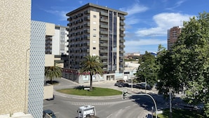 A multi-story building with balconies, a roundabout, and a parked truck. - Hostel Paris (Marinha Grande)