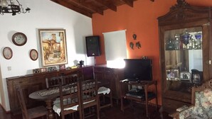 A traditional living room with wooden furniture, a television, and a cabinet with glass doors. - Rent Villa General Belgrano, Calamuchita (Los Reartes)