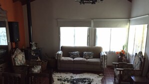 A cozy living room with a sofa, chairs, a patterned rug, and a cowhide rug. - Rent Villa General Belgrano, Calamuchita (Los Reartes)