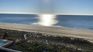A beach with a clear sky, a pool, and a fenced area. - Direct Oceanfront Condo remodeled with Breathtaking Views from two private decks (Ocean City)