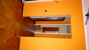 A room with orange walls, a wooden floor, and a small window. - inn Stellone of Marco Pastore (Villastellone)
