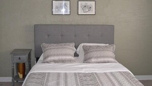 A neatly made bed with a grey headboard, two pillows, and a grey nightstand with a drawer. - Discover "a Perfect Place" in Grand Forks (Grand Forks)
