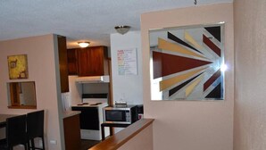 A kitchen with a microwave, stove, and wooden cabinets. - Discover "a Perfect Place" in Grand Forks (Grand Forks)