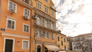 Un edificio de varios pisos con balcones, una tienda en la planta baja y un letrero que indica una joyería.