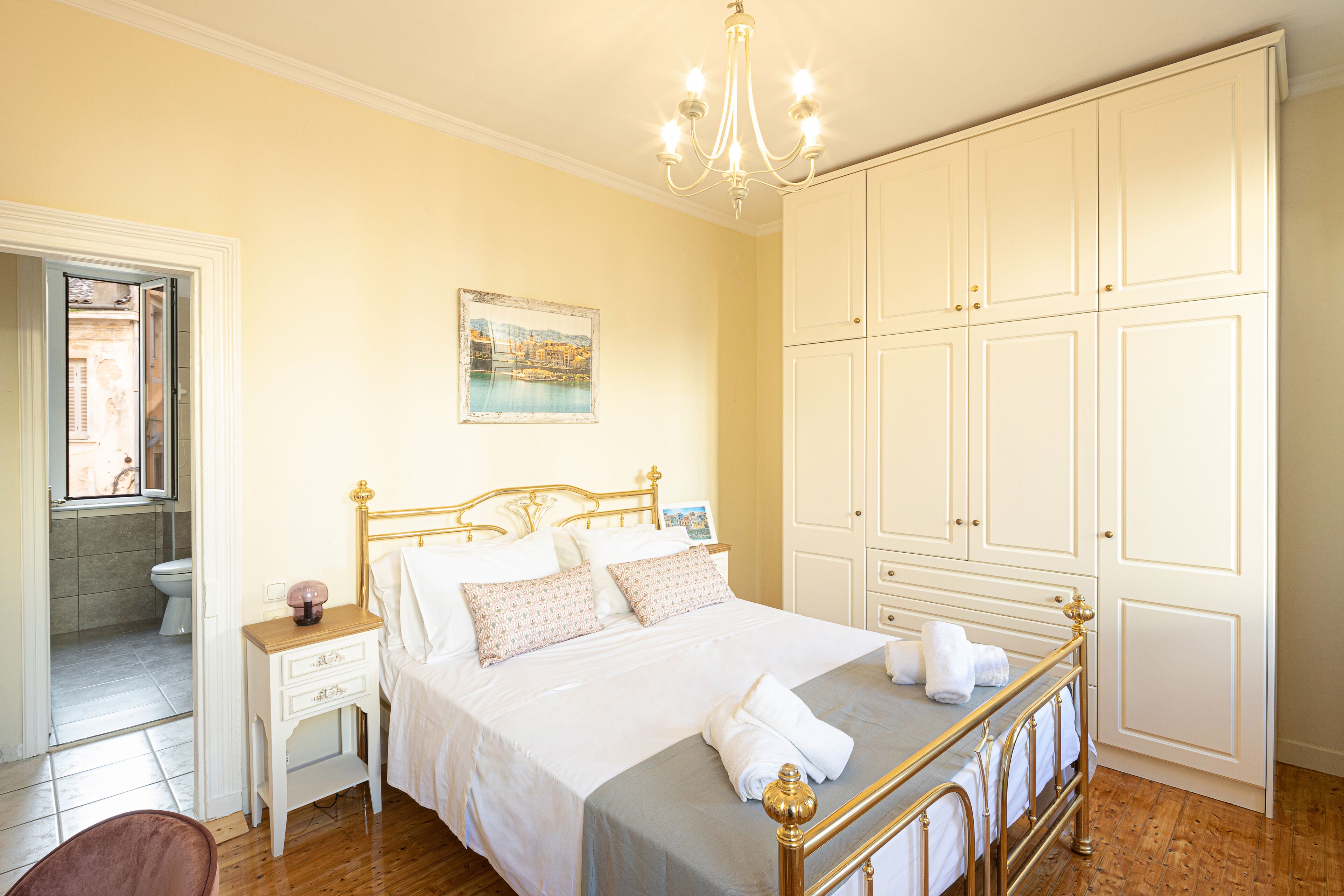 A bedroom with a bed, bedside table, nightstand, and wardrobe.