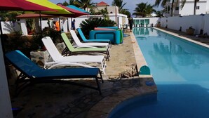 A poolside area with lounge chairs and umbrellas.