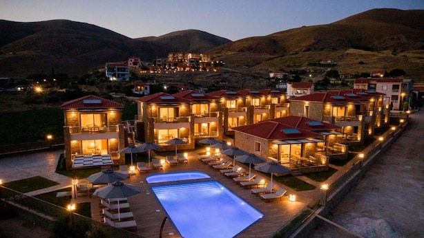 Un resort con varias construcciones, piscina y zonas de estar al aire libre.
