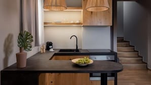 Una cocina moderna con armarios de madera, encimera negra y luces colgantes.