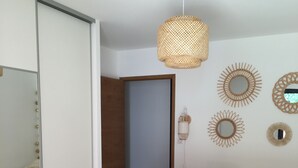 Een slaapkamer met een groot bed, een garderobe, een spiegel en decoratieve wandspiegels.
