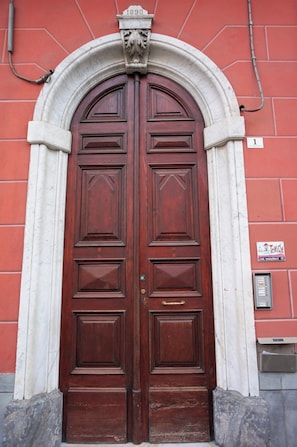 A double wooden door with a white architrave and a plaque above it. - Family House La Spezia - 5lands By Train (La Spezia)