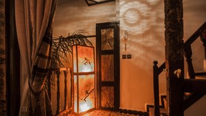 A room with a patterned floor, a wooden staircase, and a door with a decorative glass panel. - Riad Bab Essaouira (Essaouira)