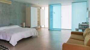 A modern hotel room with a bed, a sofa, a bathroom with a shower, and a large window. - Magnificent Loft in the Best Area of Acapulco (Acapulco)