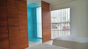 A bedroom with two beds, a wooden wardrobe, and a bathroom with a blue shower. - Magnificent Loft in the Best Area of Acapulco (Acapulco)