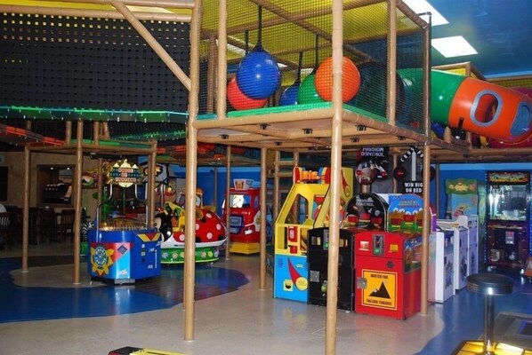 An indoor play area with various arcade games and a climbing structure.