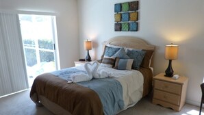 A bedroom with a bed, two bedside tables, a nightstand, a window with blinds, and a wall-mounted artwork. - Tm148or 4 Bedroom Home by RedAwning (Davenport)