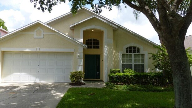 A single-story house with a garage, a front door, and a small front yard with a tree and shrubs. - Tm148or 4 Bedroom Home by RedAwning (Davenport)