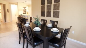 A dining area with a black table set for six, surrounded by six chairs. - 12-103 3 Bedroom Home by RedAwning (Orlando)