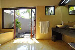 A bathroom with a large window, a sink, and a towel rack.