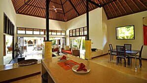 A spacious dining area with a high ceiling and large windows, a seating arrangement with tables and chairs, and a view of the outdoors. - Two Bedrooms Villa With Private Pool, Large Landscape Garden and Kitchen (Karangasem)