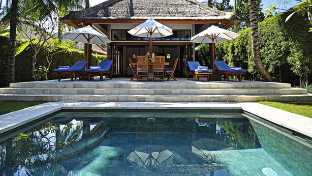 A private pool with lounge chairs and umbrellas, surrounded by palm trees and a thatched-roof structure. - Two Bedrooms Villa With Private Pool, Large Landscape Garden and Kitchen (Karangasem)