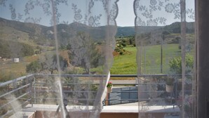 A balcony with a view of a green landscape, including hills and a clear sky. - Casa Verde - Relaxing in Nature (Kos)