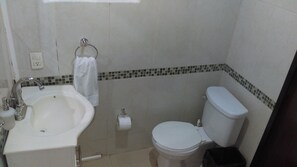 A bathroom with a sink, toilet, and a towel rack.