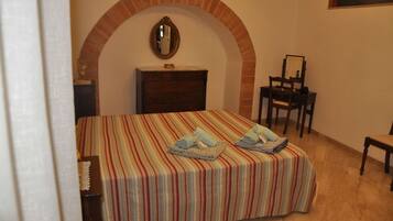 A bedroom with a bed, a dresser, a mirror, and a chair.