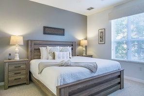 A bedroom with a large bed, two bedside tables, and a window with blinds. - Casa Nova Deluxe Townhome 3 Bedroom Townhouse by RedAwning (Orlando)