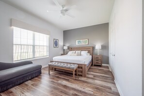 A bedroom with a bed, bench, nightstands, and a ceiling fan. - Casa Toscana Deluxe 3 Bedroom Condo by RedAwning (Orlando)