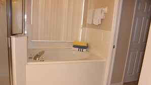 A bathroom with a bathtub, a mirror, a window with blinds, and a towel rack. - Little Mermaid Villa- Beautiful Private Villa (Haines City)