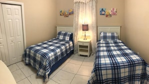 A bedroom with two beds, a nightstand, a lamp, and a door. - Little Mermaid Villa- Beautiful Private Villa (Haines City)