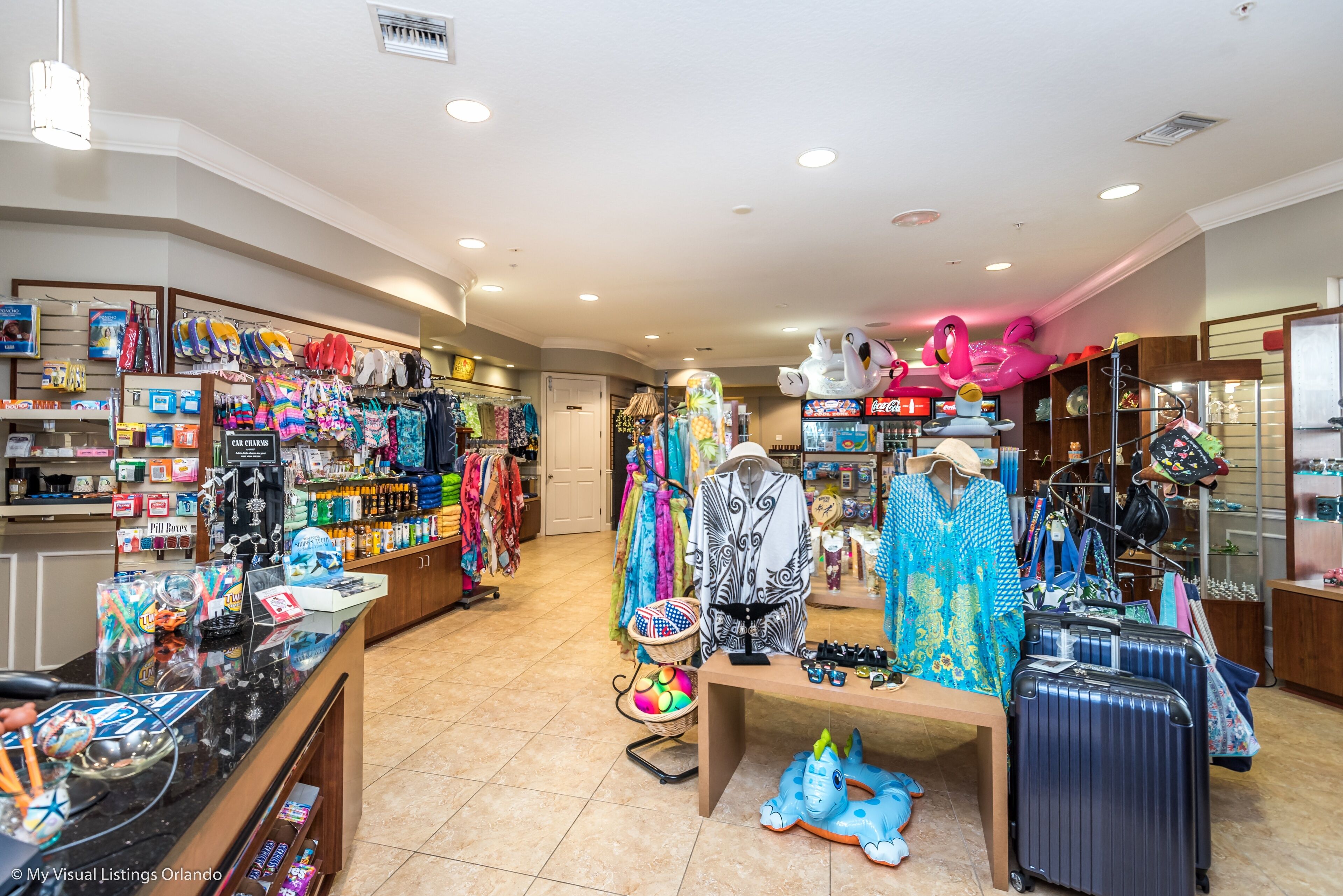 A retail store with various clothing items, accessories, and luggage displayed on shelves and tables.