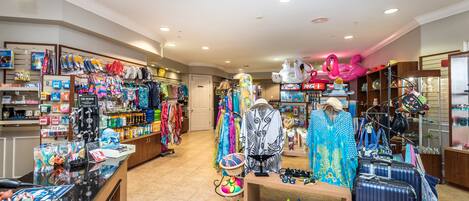 A retail store with various clothing items, accessories, and luggage displayed on shelves and tables.