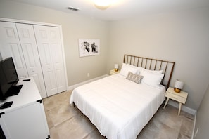 A bedroom with a bed, bedside tables, a desk with a computer, and a wardrobe. - Greater Groves - 5 Bedrooms House w/pool-5202GG Home by RedAwning (Clermont)