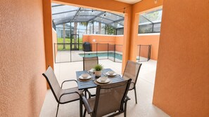A dining area with a table set for four, chairs, and a potted plant. - Paradise Palms-4 Bed W/splashpool-3610pp 4 Bedroom Townhouse by RedAwning (Kissimmee)