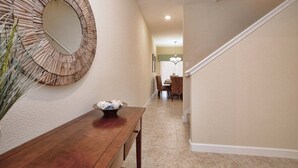 A hallway with a wooden bench, a decorative mirror, and a staircase. - Paradise Palms-4 Bed W/splashpool-3610pp 4 Bedroom Townhouse by RedAwning (Kissimmee)